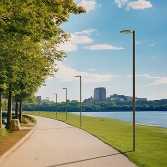 AEC Illuminazione's NOOS Street Light in a public realm location on columns amongst the trees with a cityscape in the background